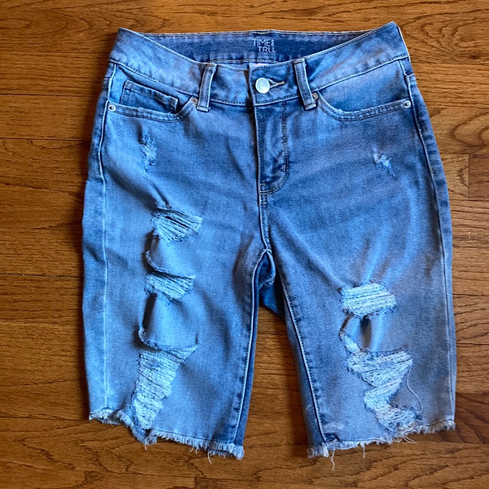 Time and tru size 4 mid thigh length jean shorts has tattered pockets and front.